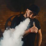 Man vaping with a cloud of vapor, enjoying e-liquids from E-Liquids Outlet.